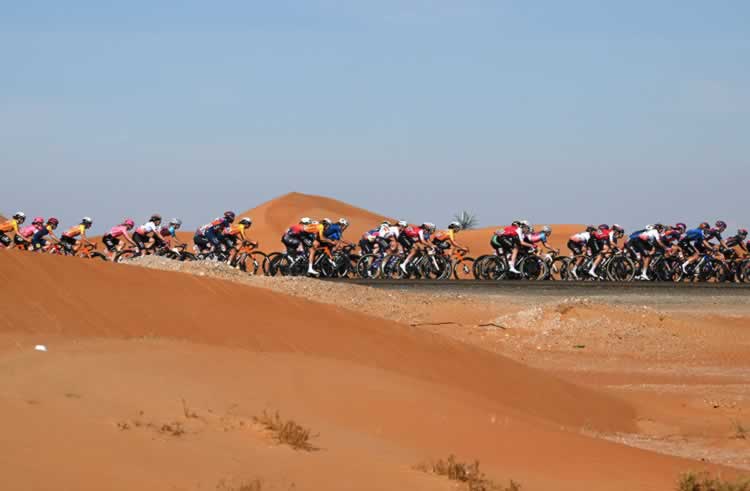 Пелотон мчится по песчаным дюнам на третьем этапе Женского Тура ОАЭ 2024.